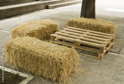 Fotografía Mesa y asientos con elementos naturales como un palé y unas balas de paja