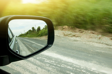 Car on the road drive to nature,Travel to clear the province, Beside with green of nature speed, Focus to mirror view backside.