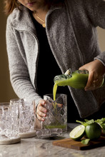 Woman Making A Cucumber Lime Cocktail
