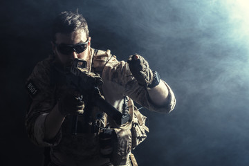 Wall Mural - Special forces soldier with rifle on dark background