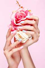 Canvas Print - Beautiful pink and blue manicure with crystals on female hand. Close-up. Picture taken in the studio