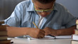 canvas print picture - Elementary school pupil diligently writing letters in his notebook, calligraphy