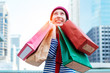 © Shutter B - Portrait of an excited beautiful young girl wear shirt and wool hat holding many shopping bags and smile. With copy space. Woman shopper smiling happy. Beautiful young Caucasian. lifestyle, discount