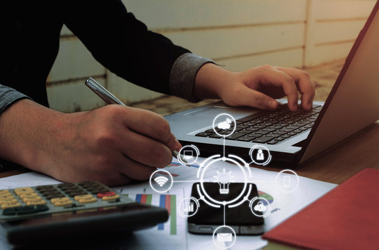 young accountant or business man working and writing with report sheet, calculator, laptop, smartphone finances and calculate on desk with graphic icon diagram, savings, business, economy concept