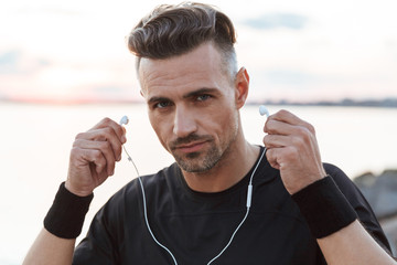 Wall Mural - Close up portrait of a confdent sportsman listening to music