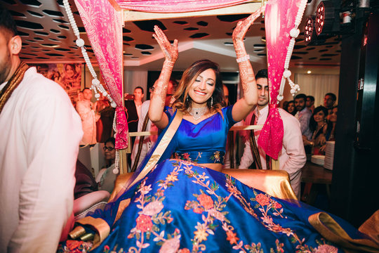 gorgeous hindu bride in blue lehenga dances on the wedding party