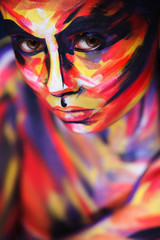 Portrait of the bright beautiful girl with painting art colorful make-up on face and bodyart. Creative vertical ads banner or flyer with copy space.