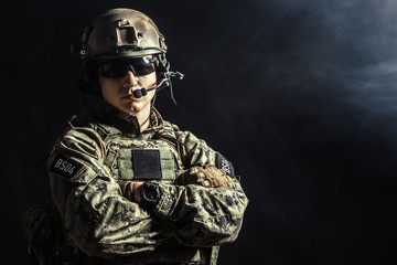 Special forces soldier with rifle on dark background