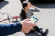 © Kzenon - Close-up of the hand of a man calling the emergency number for helping an injured woman after bicycle accident on the street