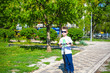 © pahis - Happy little boy rides scooter on the road in park