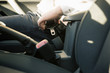 Men's hand fastens the seat belt of the car. Drive safely concept