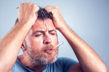 Sick man with thermometer in mouth,looking and worry at thermometer on white background,healthcare concept