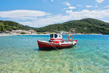Small Red Fishing Boat At Panormos Bay In Front Of Panormos Beach, Island Of Skopelos, Greece