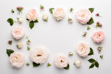 Floral Frame Made Of Pink Roses And Green Leaves On White Background. Flat Lay, Top View. Valentine's Background.