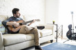 © AntonioDiaz - Young guy playing guitar at home