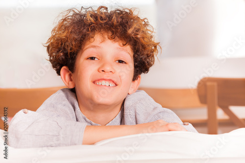 Fotografia, Obraz Happy preteen boy sitting backwards on white sofa