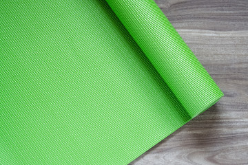 Poster - Green yoga mat on a wooden background, Top View with copy space. Actie healthy lifestyle background concept.