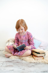 Wall Mural - A girl in a dress is reading a book