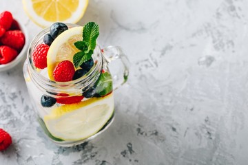 Canvas Print - Infused detox water with lemon slice, raspberry, blueberry and mint. Ice cold summer cocktail or lemonade in mason jar