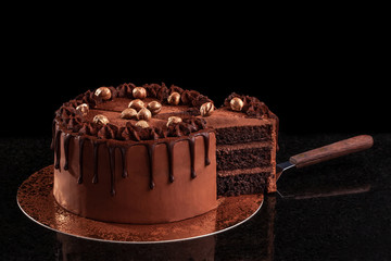 Chocolate cake with nuts on a black background