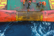 Offshore Worker Performing Anchor Handling Job At The Stern Of An Anchor Handling Tug Boat At Oil Field