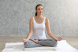 © thbangkok - Young caucasian very attractive woman practicing yoga, sitting in Padmasana doing yoga exercise or Lotus pose or namaste pose. Working out on her bed.
