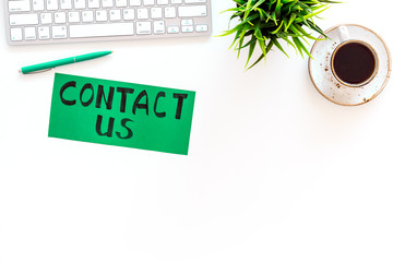 Poster - Frame contact us. Lettering Contact us on office work desk with computer on white background top view copy space