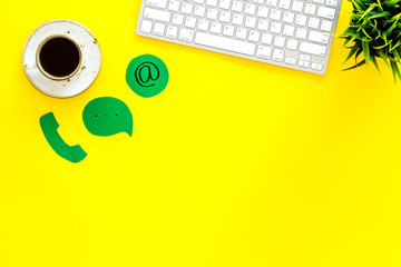 Poster - Customer service concept. Concact information. Phone, message, email signs on office work desk with computer on yellow background top view copy space