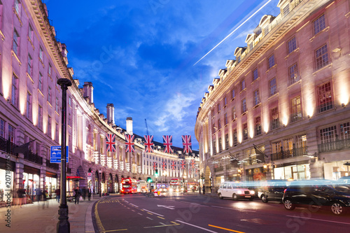 Cuadros en Lienzo Popular tourist Regent street with flags union jack in night lights illumination
