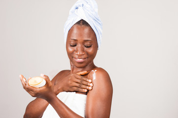 beautiful african woman putting on ointment.