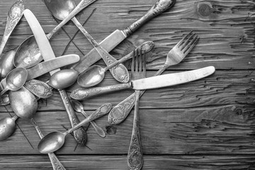 Old vintage ornamented cutlery on a wooden table