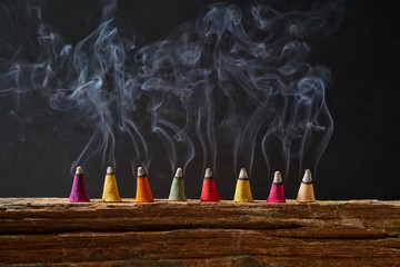 Incense sticks on old wood with smoke and black background