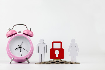 pink alarm clock, wooden person model and coin on a wooden on white background