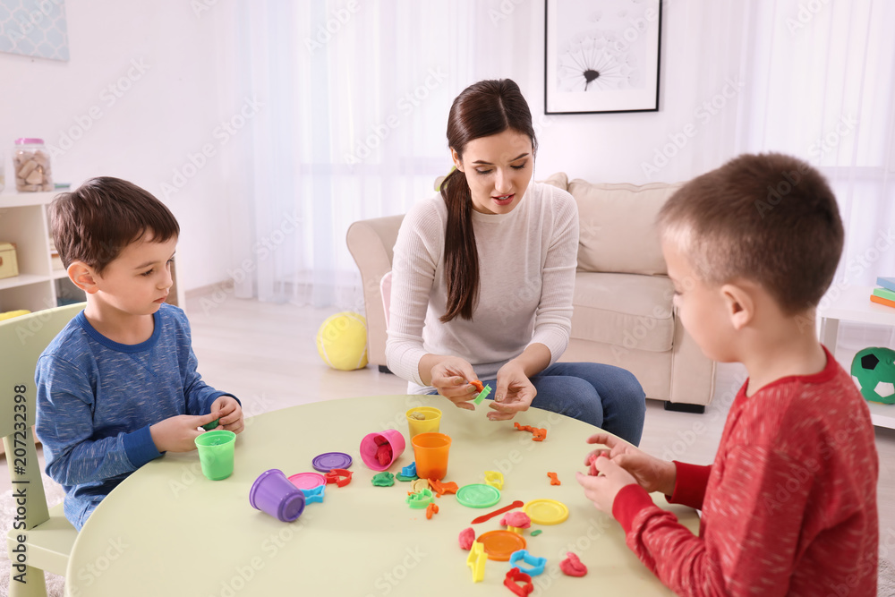 Nanny and little boys sculpting from plasticine at home