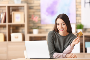 Canvas Print - Young woman shopping online with credit card and laptop at table