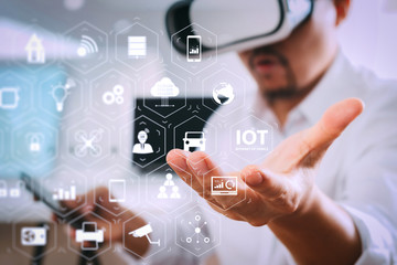 Poster - businessman wearing virtual reality goggles in modern office with mobile phone using with VR headset