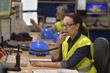 © goodluz - Woman in industrial control room using radio to give instructions