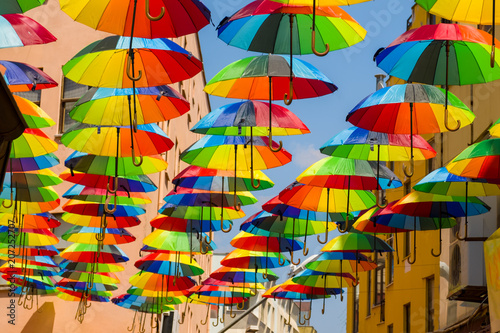 Multicolored, rainbow, umbrellas hung over the street.