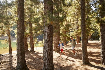 Wall Mural - Father And Son On Hiking Adventure Running Through Forest