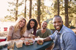 © Monkey Business - Portrait Of Couple With Friends Camping By Lake In Forest