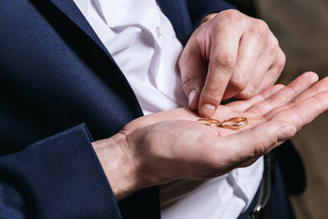 Wall Mural - groom holds the wedding rings on the palm