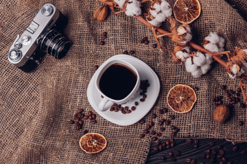 Dry cotton old retro camera and coffee on a rustic table with bu