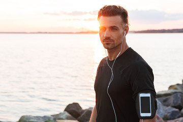 Wall Mural - Portrait of a handsome sportsman listening to music