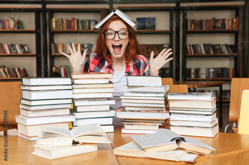 Fotografía Excited teenage girl sitting at the library table