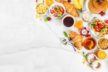 Healthy breakfast eating concept, various morning food - pancakes, waffles, croissant oatmeal sandwich and granola with yogurt, fruit, berries, coffee, tea, orange juice, white background