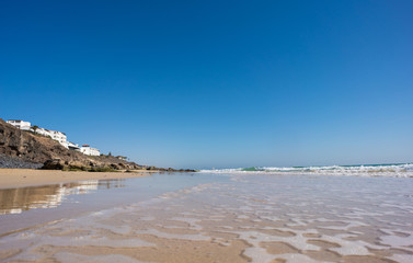 Sticker - Calm sea and surf on a sandy beach. summer sea in Sunny weather with blue sky. Beautiful sandy beach and transparent waves