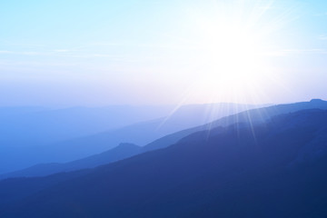 Wall Mural - sunset in the mountains. colorful landscape with sun and blue sky