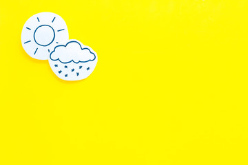 Wall Mural - clear and cloudly weather icons on yellow background top view copy space