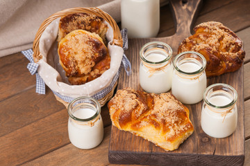 Wall Mural - Jars with milk and bread buns on a cutting board 