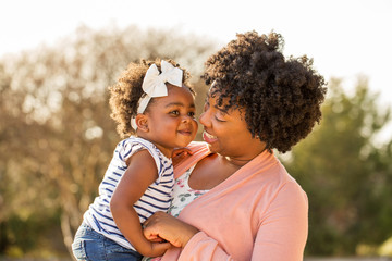 african american mother holding her daughter.